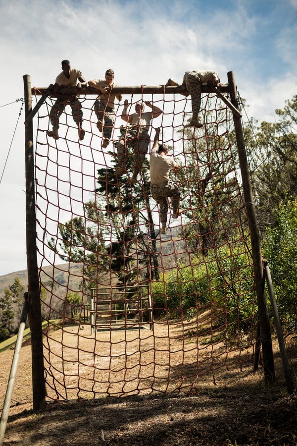 Military Soldiers Climbing Rope during Obstacle Course Stock Photo