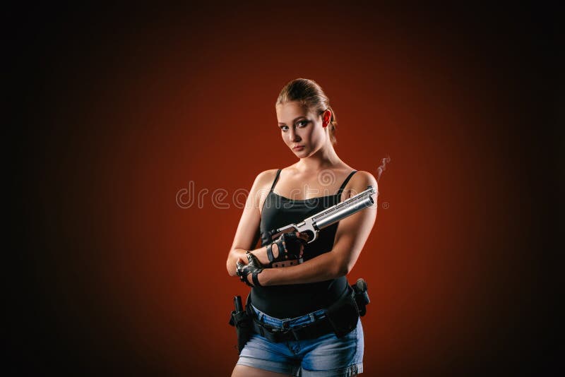 Military woman with a sport gun over black background