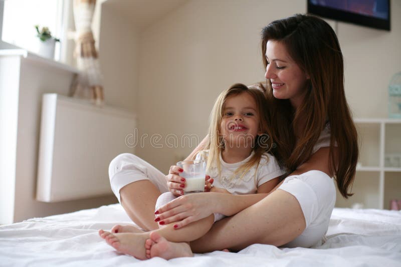 Milk before Bed. Mother and Daughter Evening Routine Stock Photo