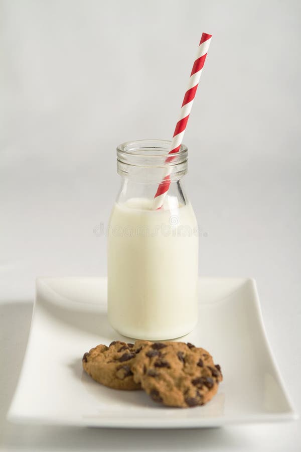 Latte e biscotti sfondo bianco e rosso a strisce di paglia su un piatto.