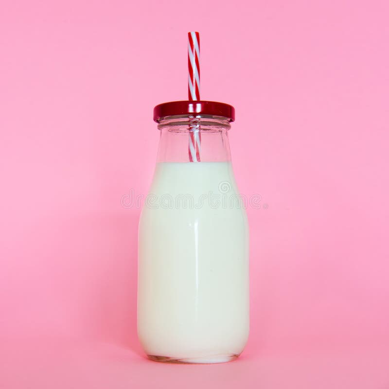 Milk Glass Bottle with Straw Isolated on Pink Background Stock Photo