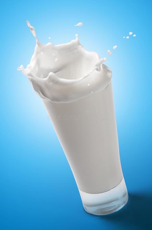 Mléko Stříkající do Sklenice Přes Modré Pozadí.