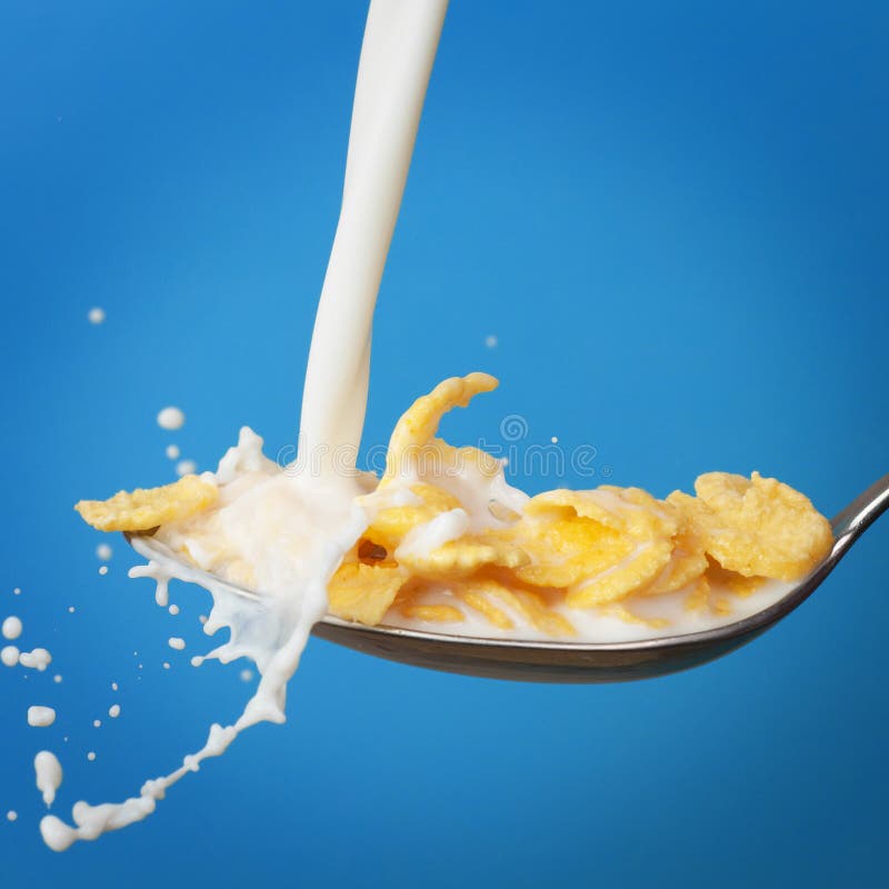 Milk splashing into spoon with cornflakes