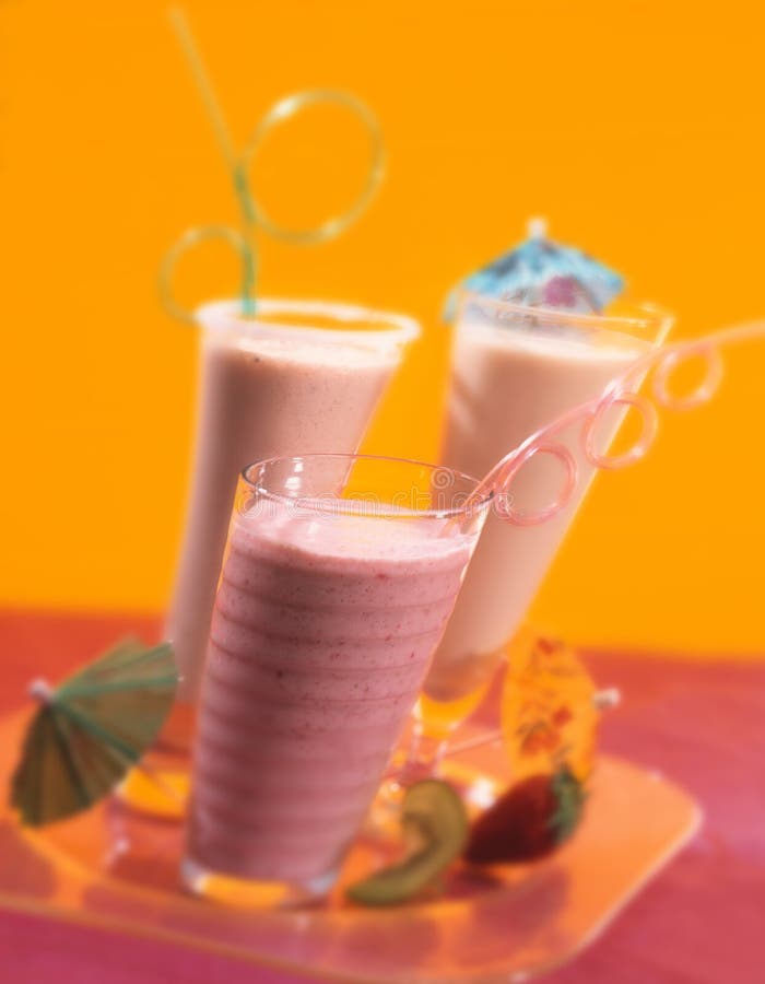 Milkshakar med att dricka sugrör på magasinet på gul bakgrund arkivbild