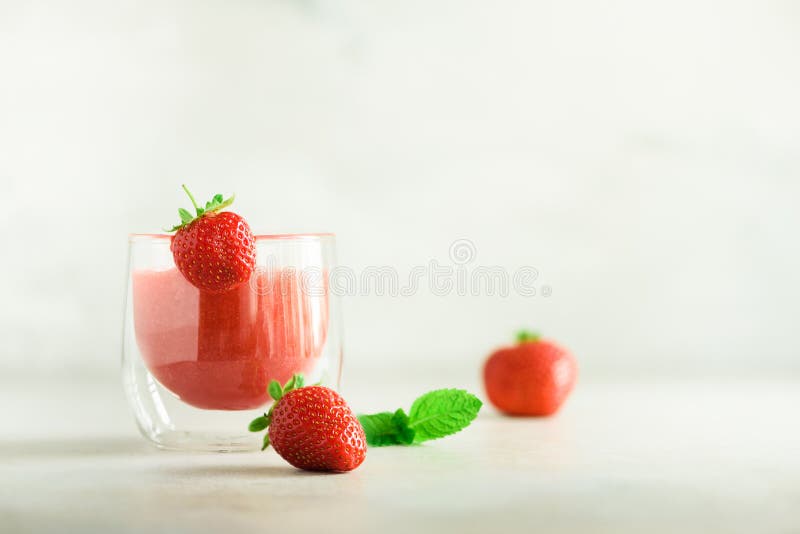 Milkshake rouge de fraise en verre sur le fond gris avec l'espace de copie Concept de nourriture d'été, régime de vegan Smoothie image stock Milkshake rouge de fraise en verre sur le fond gris avec l'espace de copie Concept de nourriture d'été, régime de vegan Smoothie image stock
