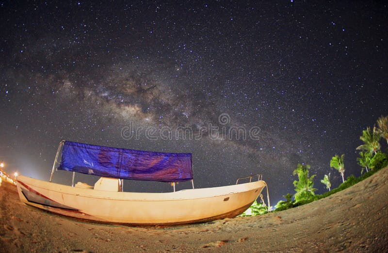 Milky way over fisherman boat at Mabul Island. Visible noise due