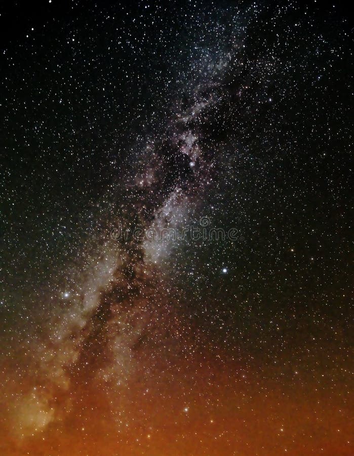 The milky way over orange lights royalty free stock image