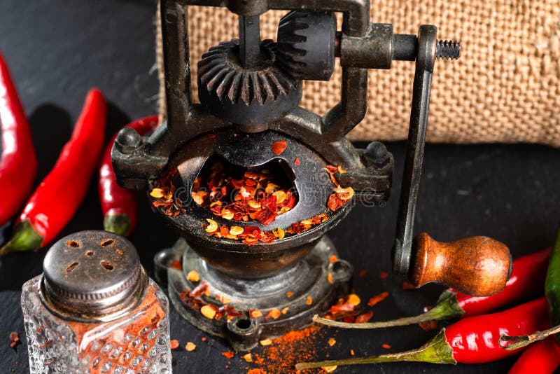 Mill and Red Hot Peppers, Pepper Pods on a Black Table Stock Image