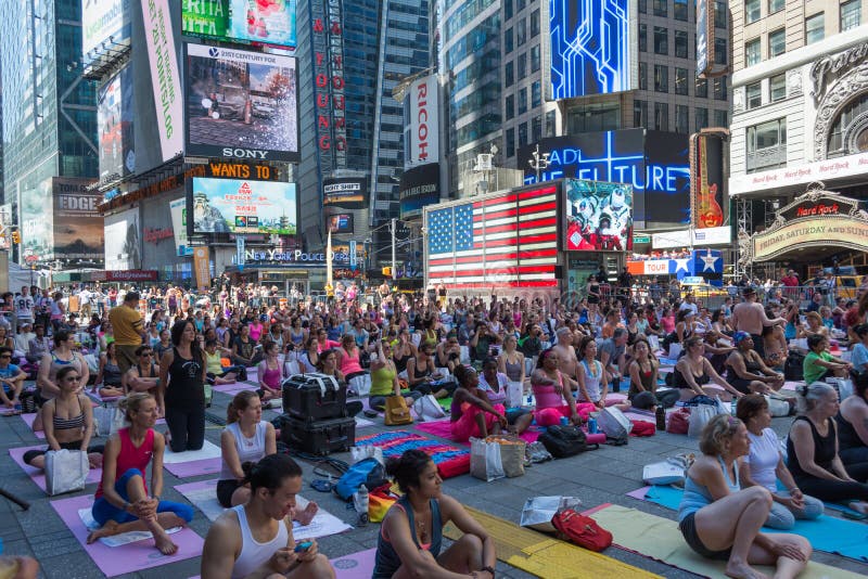 Millares de neoyorquinos que practican yoga en Times Square foto de archivo libre de regalías Millares de neoyorquinos que practican yoga en Times Square foto de archivo libre de regalías