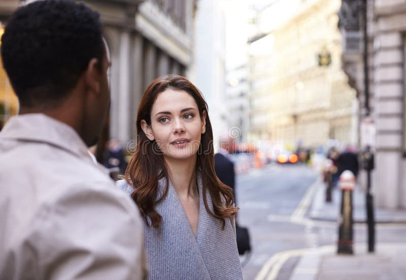 Millennial affärskollegor som står på en gata i London som har en konversation, slut upp