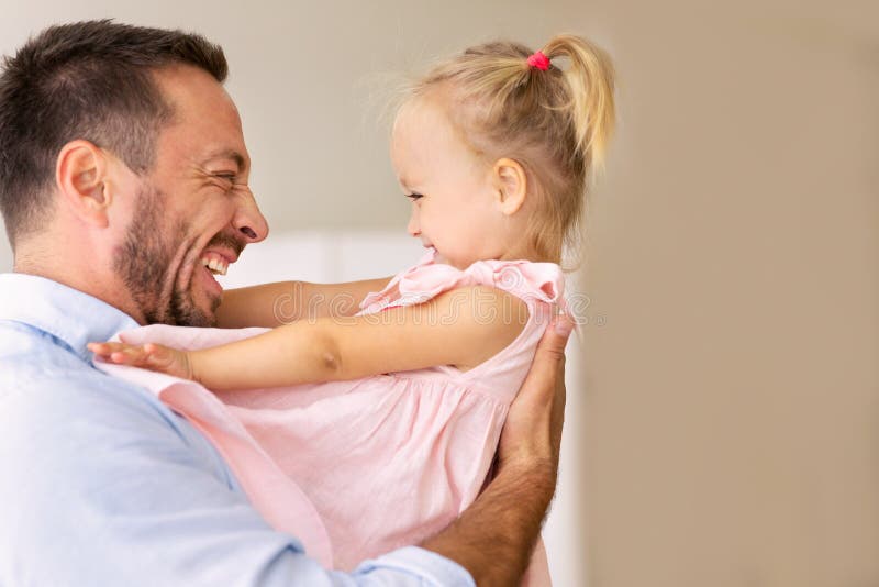 His loving daughter. Папа держит в руках подарок дочери. Папа защекотал дочку.