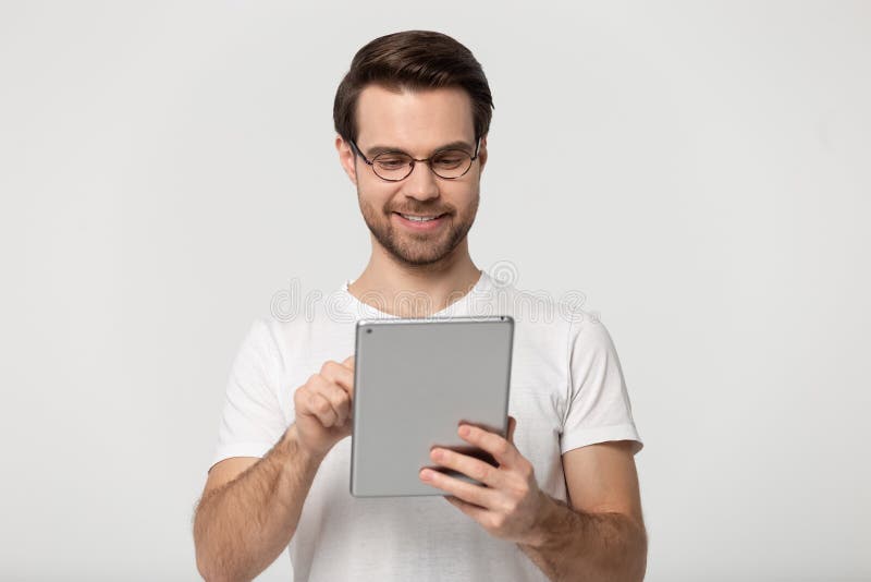 Millennial grabb i exponeringsglas genom att använda minnestavlan som isoleras på grå bakgrund arkivfoton Millennial grabb i exponeringsglas genom att använda minnestavlan som isoleras på grå bakgrund arkivfoton