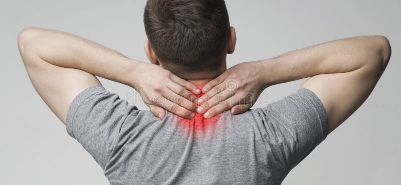 Painful feeling in spine. Millennial guy touching his sore neck, back view. Painful feeling in spine. Millennial guy touching his sore neck, back view