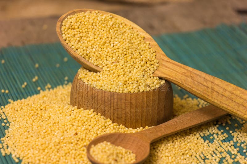 Heap Of Millet Groats With Spoon On Wooden Background Stock Photo