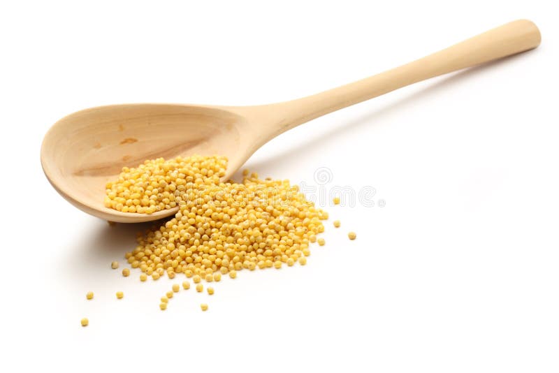 Millet groats with wooden spoon stock images