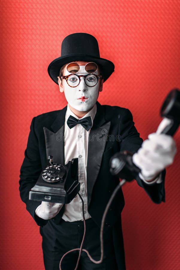 Mime theater actor performing with old telephone.