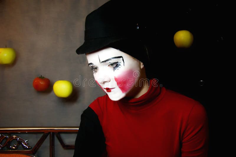 Mime triste in un cappello con le mele fotografia stock Mime triste in un cappello con le mele fotografia stock