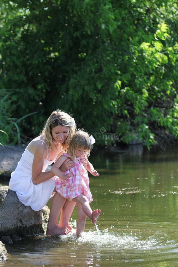 Mime Y Su Pequeña Hija Que Arroja A Chorros El Agua En El Lago Imagen
