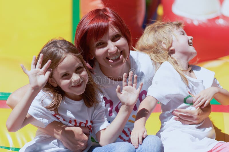 Mime y sus hijas que se divierten en castillo de salto fotografía de archivo libre de regalías Mime y sus hijas que se divierten en castillo de salto fotografía de archivo libre de regalías