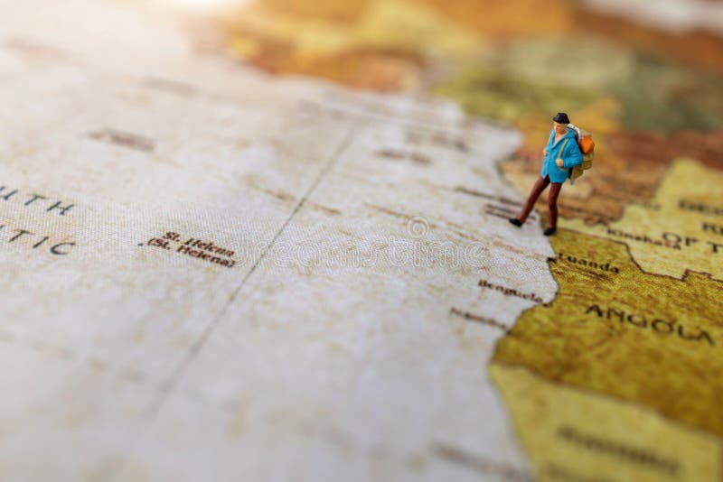 Minature people: traveling with a backpack standing on vintage world map. stock images Minature people: traveling with a backpack standing on vintage world map. stock images