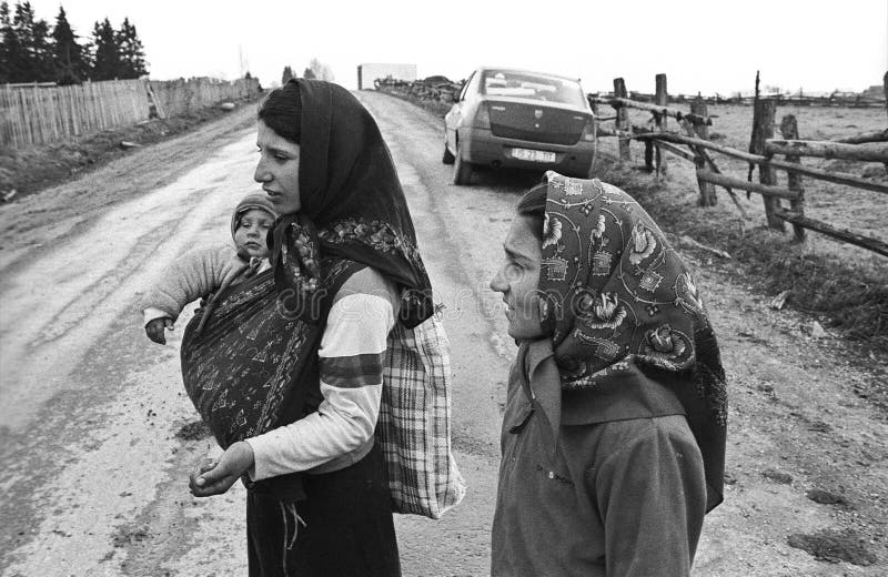 Minor gypsy beggars with baby on rural road in Romania, Marisel town. Film scan. Minor gypsy beggars with baby on rural road in Romania, Marisel town. Film scan