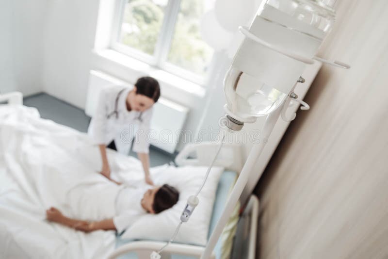 Mindful nurse talking to girl with drop counter stock image Mindful nurse talking to girl with drop counter stock image