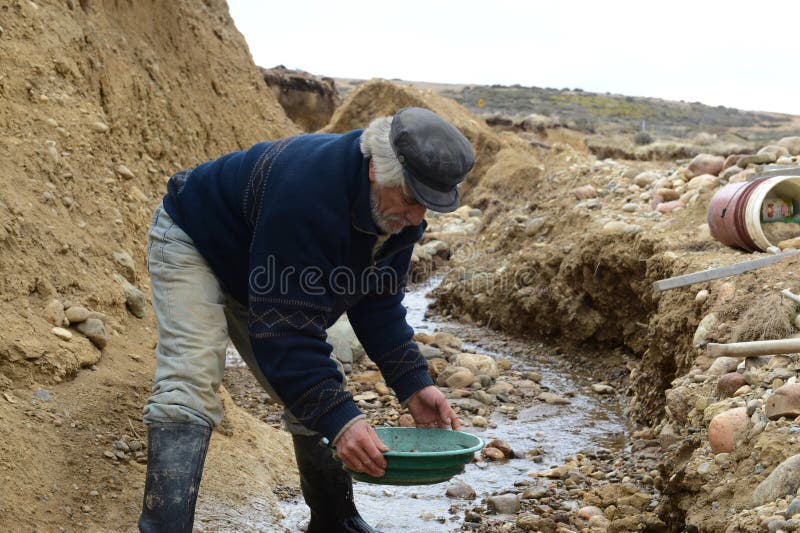 Gold Digger Shows Tourists Alluvial Gold Sand Mined in the Mine on