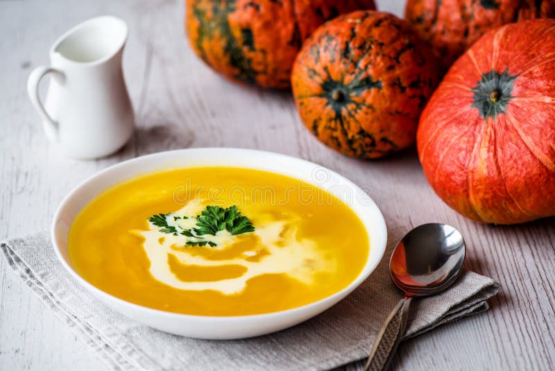 Minestra della zucca con crema e prezzemolo Alimento del vegano fotografia stock Minestra della zucca con crema e prezzemolo Alimento del vegano fotografia stock