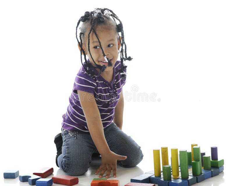 An adorable preschooler looking for approval for the block creation she's just made. On a white background. An adorable preschooler looking for approval for the block creation she's just made. On a white background.