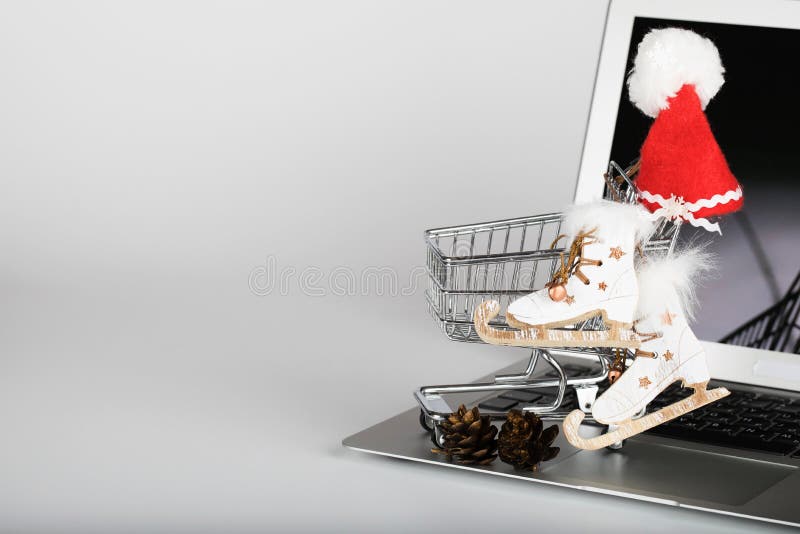 Mini carrello con il cappello di Santa Claus ed i pattini da ghiaccio decorativi di legno immagine stock libera da diritti Mini carrello con il cappello di Santa Claus ed i pattini da ghiaccio decorativi di legno immagine stock libera da diritti