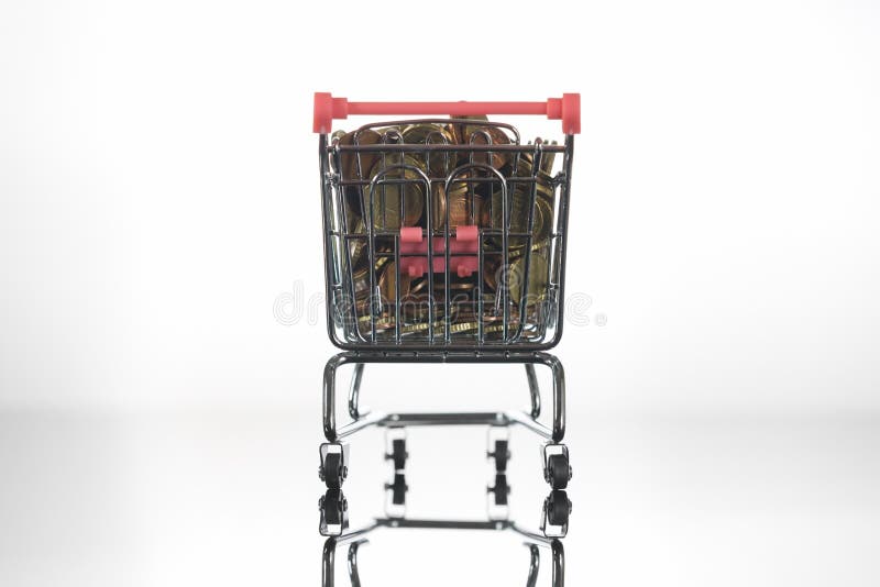 Mini Chrome Shopping Cart fylld överst med mynt arkivbild Mini Chrome Shopping Cart fylld överst med mynt arkivbild