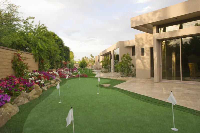 View of mini golf course in garden by luxury house. View of mini golf course in garden by luxury house