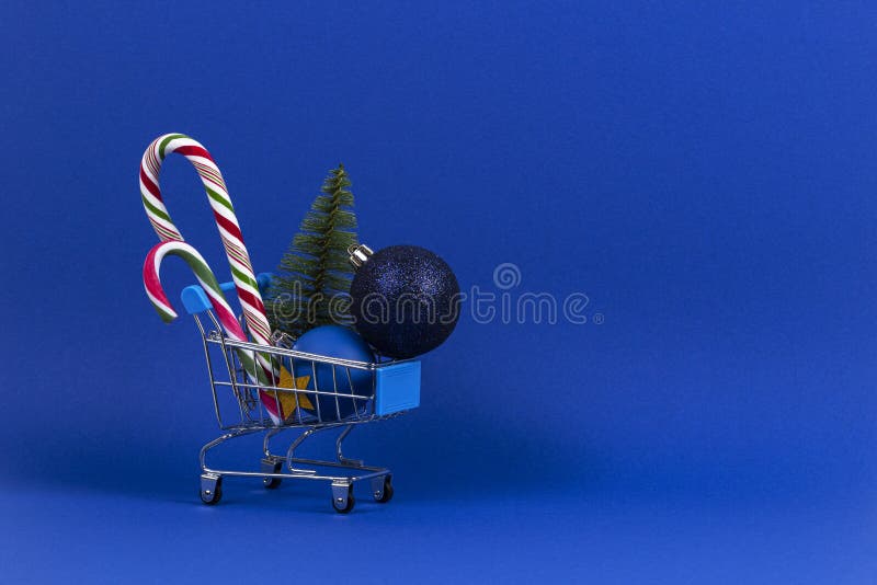 Mini koszyk z małą choinką, Xmas dekoracyjne kule i cukierki na niebieskim tle fotografia royalty free Mini koszyk z małą choinką, Xmas dekoracyjne kule i cukierki na niebieskim tle fotografia royalty free