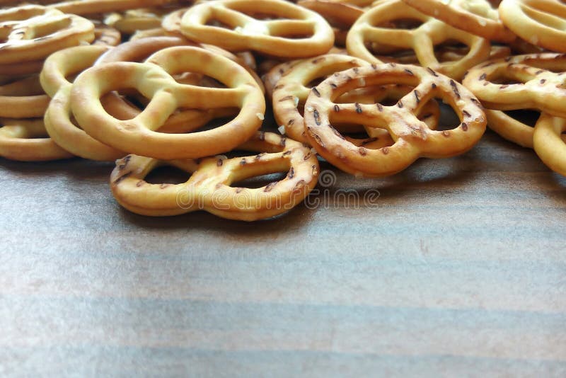Mini- kringlor för salt frasig smällare på trätabellbakgrund royaltyfri bild Mini- kringlor för salt frasig smällare på trätabellbakgrund royaltyfri bild