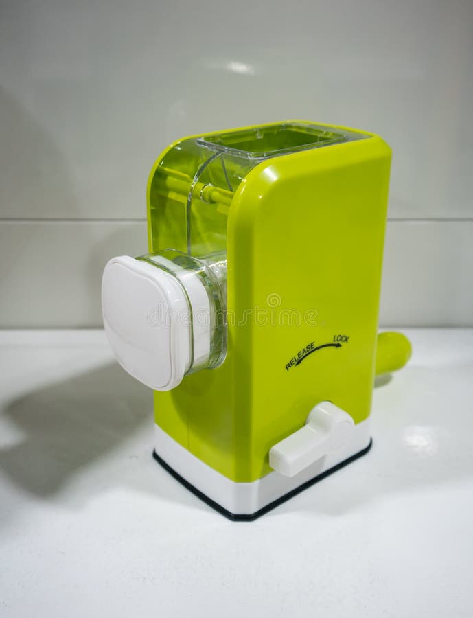 Mini- kökhjälpmedel för manuell köttkvarn med plast- containe royaltyfri bild Mini- kökhjälpmedel för manuell köttkvarn med plast- containe royaltyfri bild