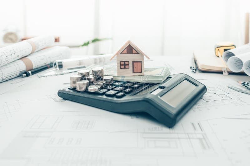 Mini Model House and Coin on Calculator. Cost Architect and Engineer