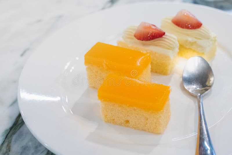 Mini-Orangenkuchen auf einem Teller mit Löffel verzehrfertig stockfotografie Mini-Orangenkuchen auf einem Teller mit Löffel verzehrfertig stockfotografie