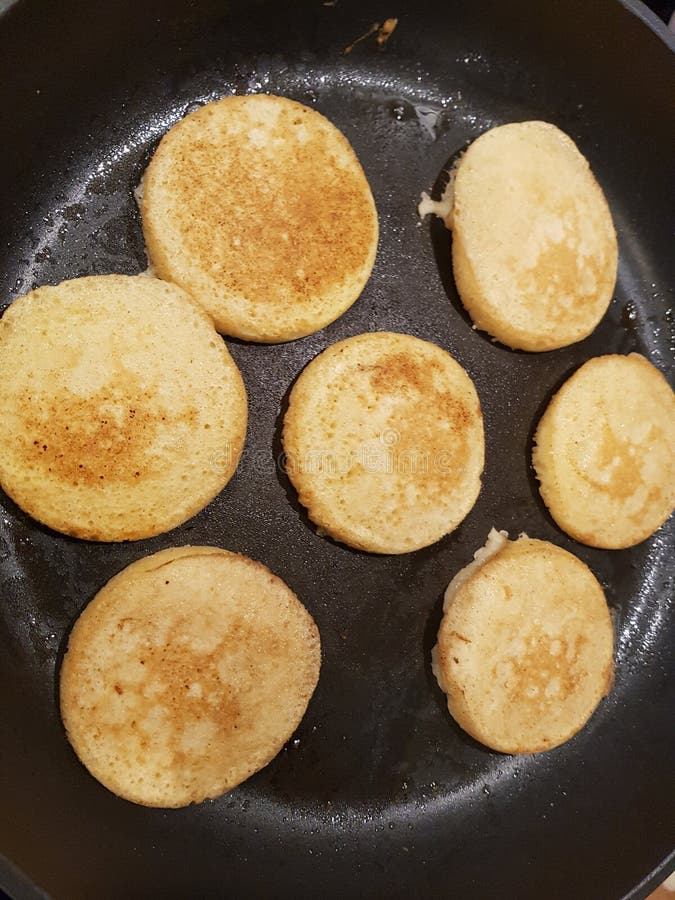 Mini Pancakes Frying On Iron Pan. Flipping Half Cooked Pancakes Around