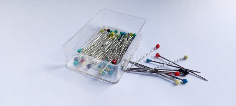 Mini pin colorido conjunto en la caja de plástico aislado en fondo blanco