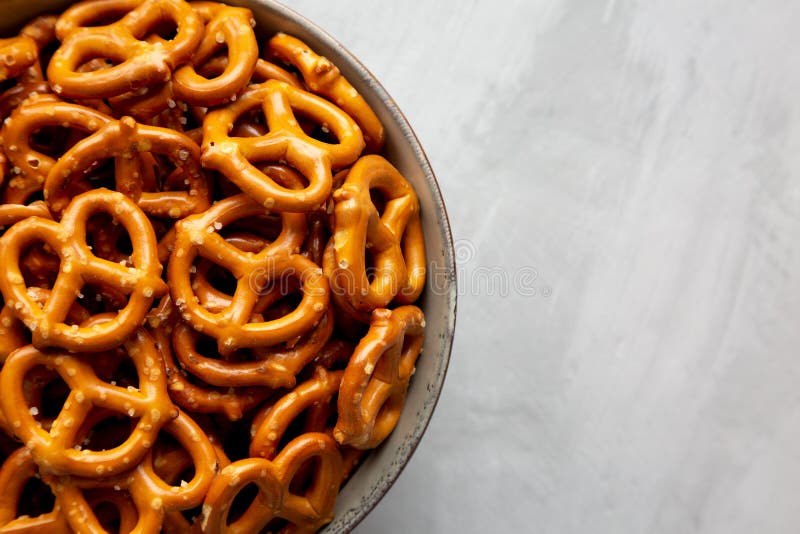 Mini Pretzels with Salt in a Bowl on a Gray Surface, Top View. Flat Lay, Overhead, from Above