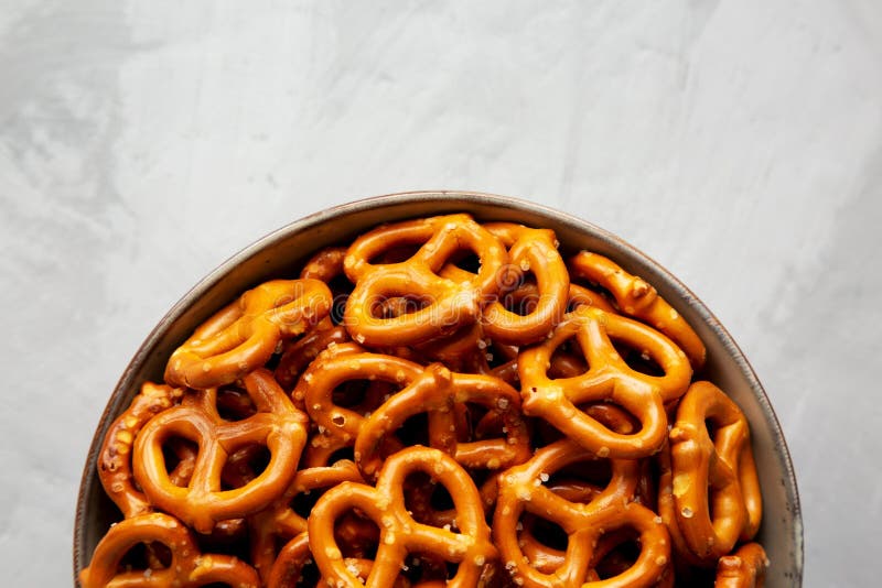 Mini Pretzels with Salt in a Bowl on a Gray Surface, Top View. Flat Lay, Overhead, from Above