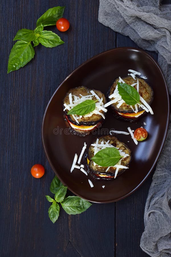Mini ratatouille. Appetizer from eggplant, zucchini, tomatoes and young cheese on a dark background. Vegetarian food. Mini ratatouille. Appetizer from eggplant stock photos Mini ratatouille. Appetizer from eggplant, zucchini, tomatoes and young cheese on a dark background. Vegetarian food. Mini ratatouille. Appetizer from eggplant stock photos