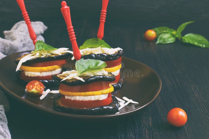 Mini ratatouille. Appetizer from eggplant, zucchini, tomatoes and young cheese on a dark background. Vegetarian food. Mini ratatouille. Appetizer from eggplant royalty free stock photography Mini ratatouille. Appetizer from eggplant, zucchini, tomatoes and young cheese on a dark background. Vegetarian food. Mini ratatouille. Appetizer from eggplant royalty free stock photography