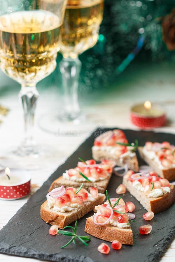 Mini sanduíches com queijo de feta, romã, as cebolas vermelhas e os alecrins foto de stock Mini sanduíches com queijo de feta, romã, as cebolas vermelhas e os alecrins foto de stock