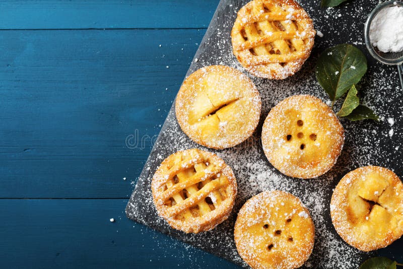 Mini tartes aux pommes délicieuses sur le fond bleu d'en haut Desserts de pâtisserie d'automne photo stock Mini tartes aux pommes délicieuses sur le fond bleu d'en haut Desserts de pâtisserie d'automne photo stock