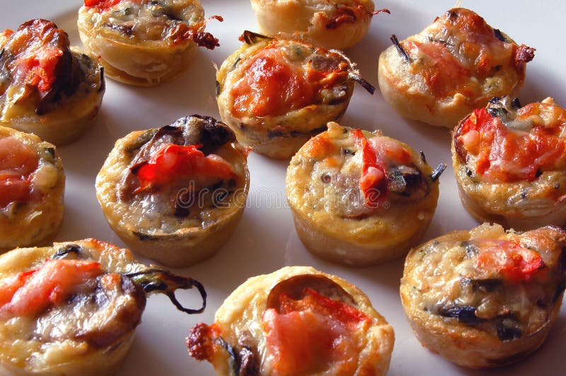 Mini tartes de tomate et de champignon de couche photographie stock libre de droits Mini tartes de tomate et de champignon de couche photographie stock libre de droits