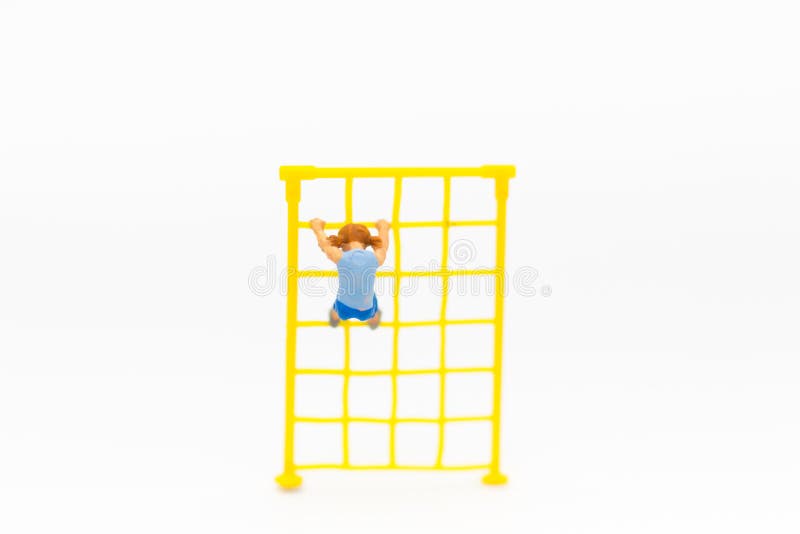 Miniature children: Girl playing rope climbing on a children`s toy. Image use for child physical Development