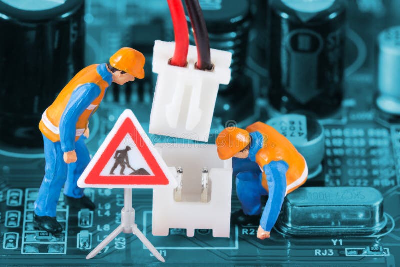Miniature engineers fixing wire connector stock photography
