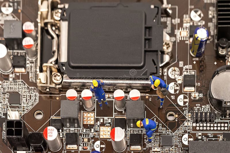 Miniature Group Engineers inspecting computer processor with chip and repairing royalty free stock photography