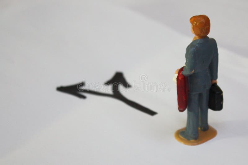 Miniature man thinking, which way to go. Decision making conceptual photo stock images Miniature man thinking, which way to go. Decision making conceptual photo stock images